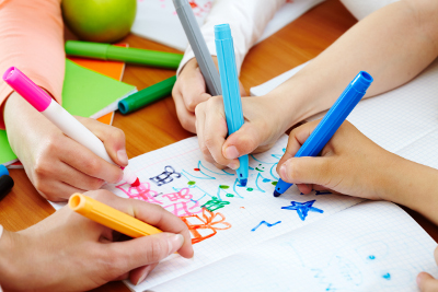 Mains d'enfants avec feutres qui dessinent